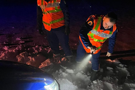 Deux secouristes de la Protection Civile Normandie Seine éclairent une voiture avec une lampe torche pour vérifier s'il y a quelqu'un à l'intérieur.